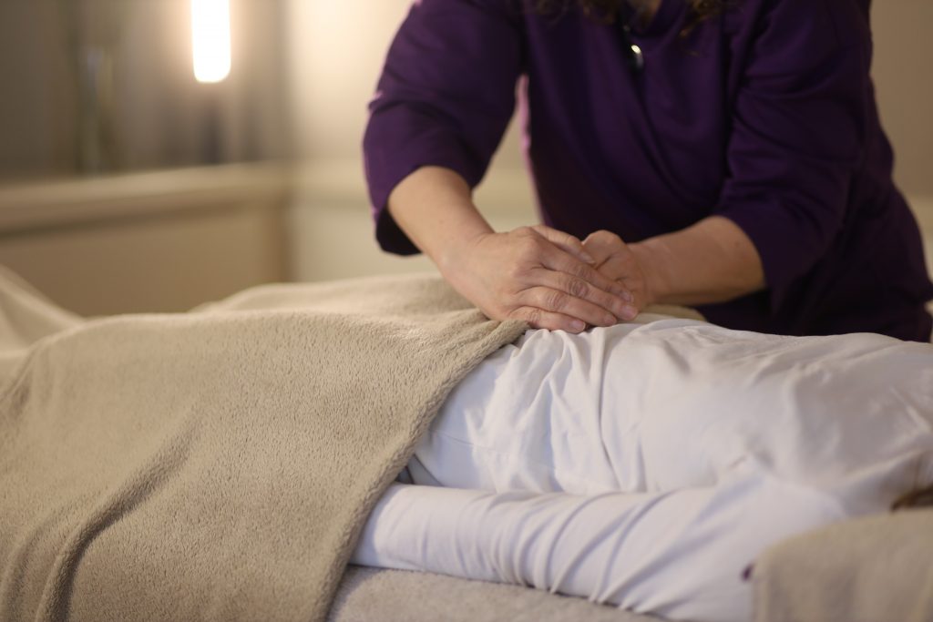 Bárbara Ramos haciendo terapia energética o Reiki Transpersonal en la camilla
